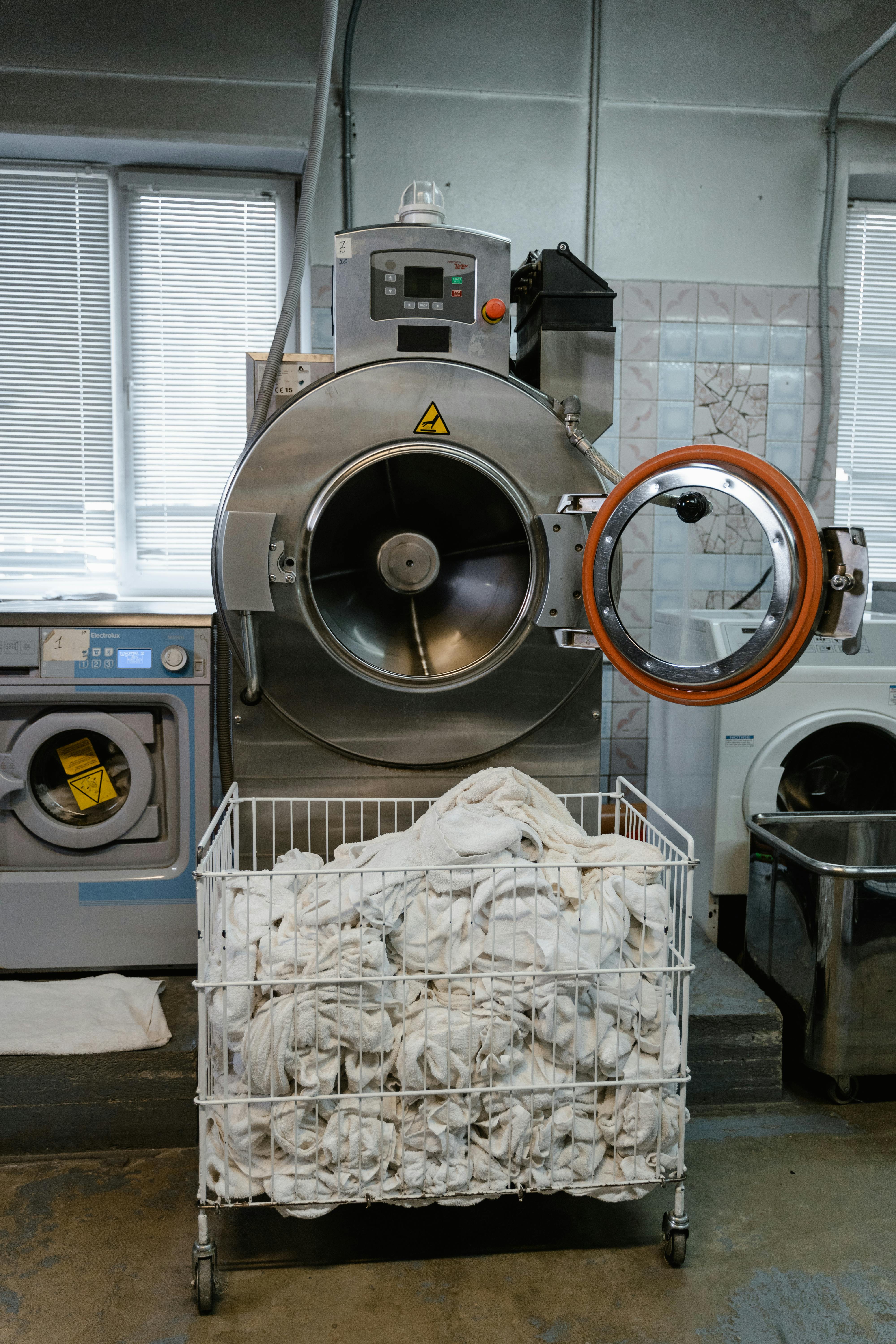 A washing machine that has broken down in a home laundry room needing professional attention